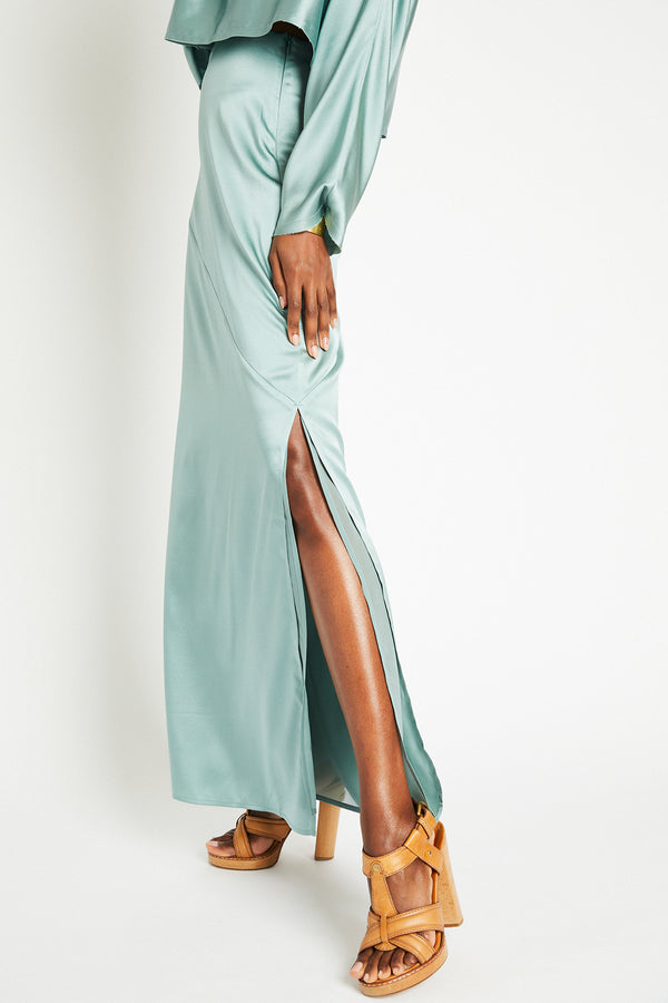 Closeup of the leg slit detail of the Naomi silk skirt in Mint (Sage Green)