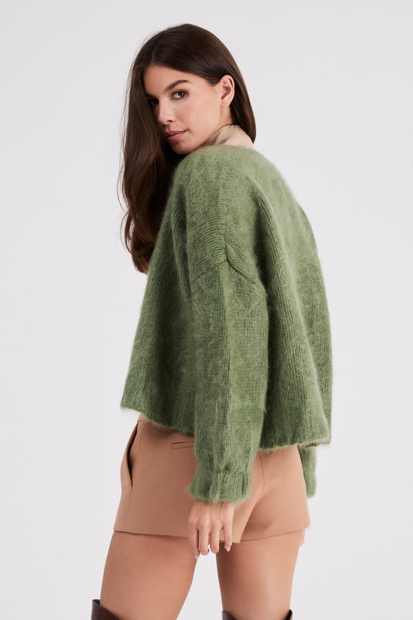 Model wearing Anita cashmere cropped cardigan in Sage Green, side view
