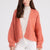 Model wearing Anita cashmere cropped cardigan in coral, front view