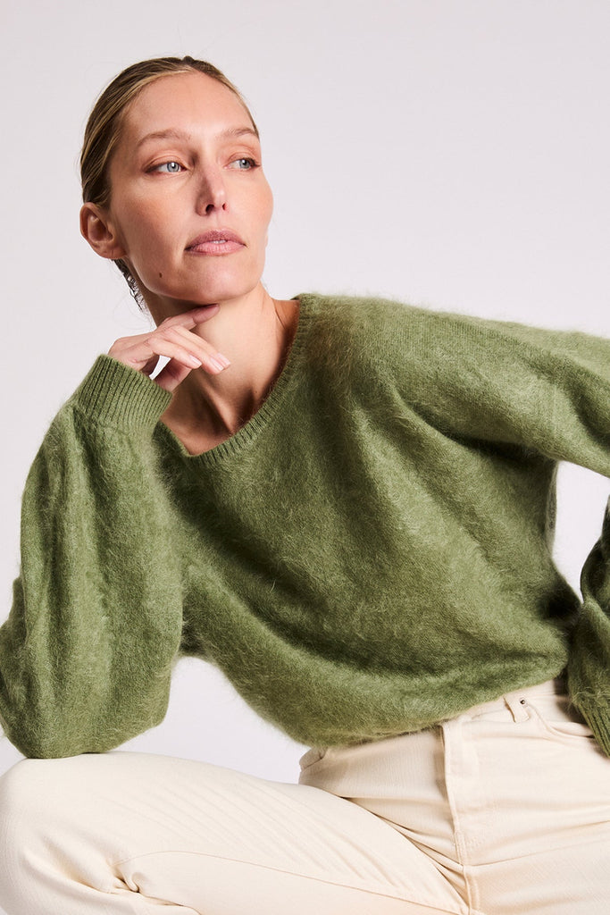 Woman wearing the Stevie green cashmere sweater by Beryll.