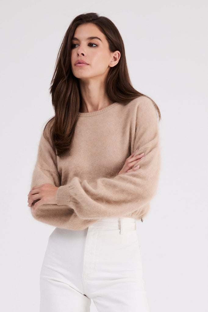 Woman wearing the Stevie beige cashmere sweater by Beryll.