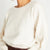 Close-up of the Stevie ivory cashmere sweater showing the premium cashmere knit and gathered waist.
